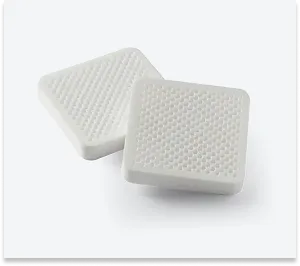 Two white components with complex, perforated geometry, 3D printed from Alumina 4N ceramic resin, resistant to high temperatures.