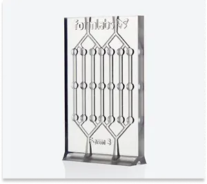 Technical component printed in 3D from transparent Clear Resin, with visible precise internal channels.