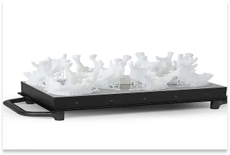 A white prototype with highly complex, organic geometry, printed from SLA resin on a working platform.