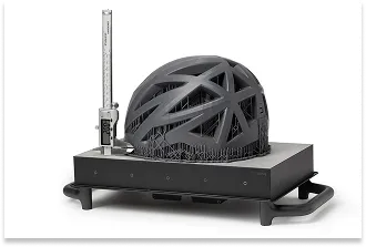 A large prototype of a bicycle helmet made of SLA resin, undergoing dimensional inspection using a digital caliper.