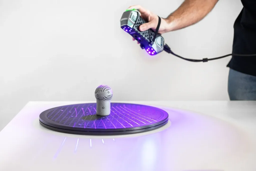 Precise 3D scanning process of an object using a handheld laser scanner.