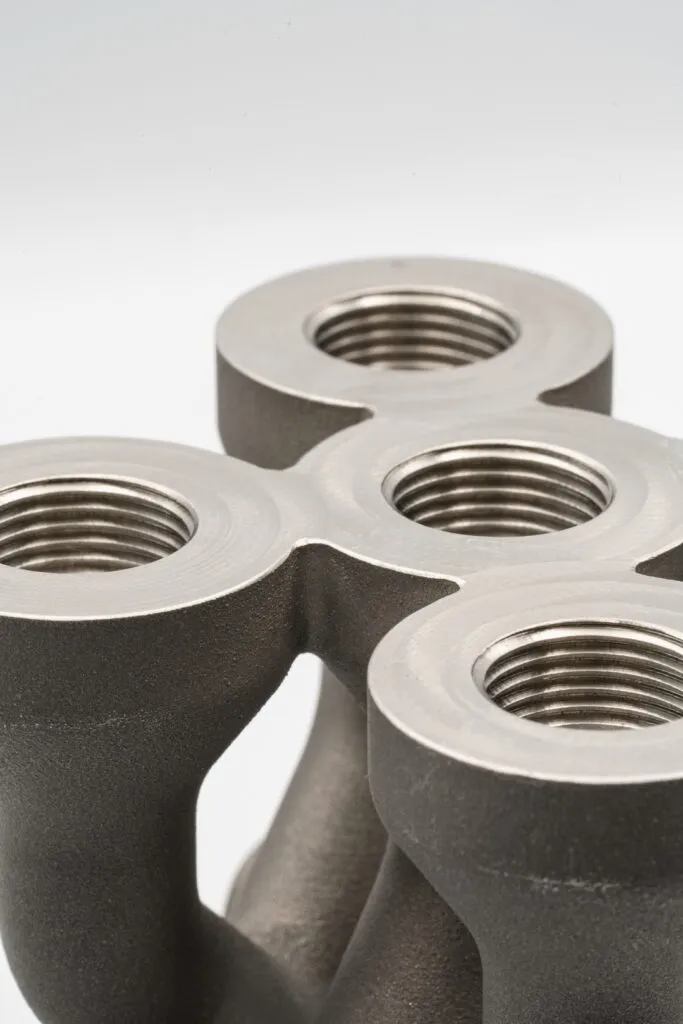 Two polymer intake restrictors for a racing car, 3D printed, showing precise mounting flanges and smooth internal transitions.