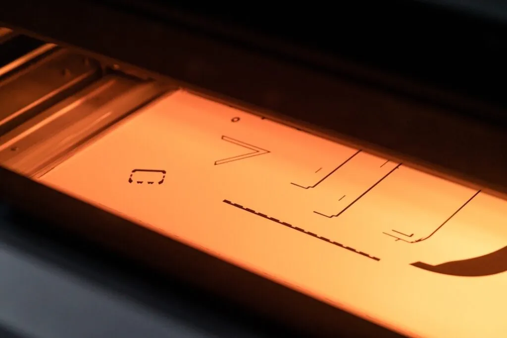 MJF plastic 3D printing process in progress, showing cross-sections of parts being printed on a polymer powder layer in the Spes3D build chamber.